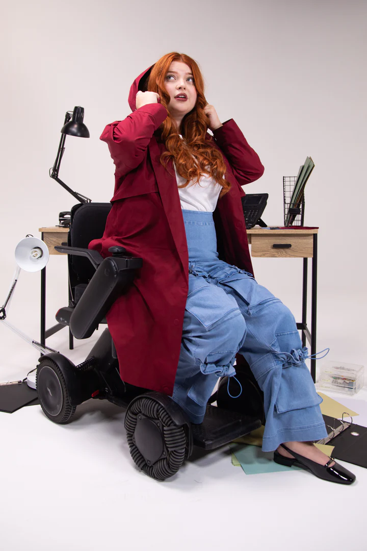 Long red hooded coat worn by red haired model in wheelchair